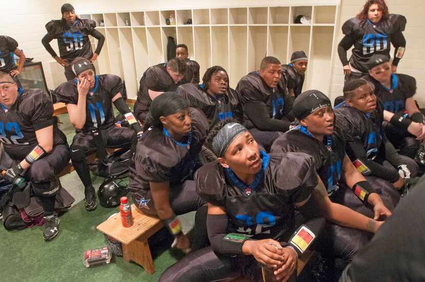 
Offensive team members of the Dallas Elite women's football team listen to assistant coach...