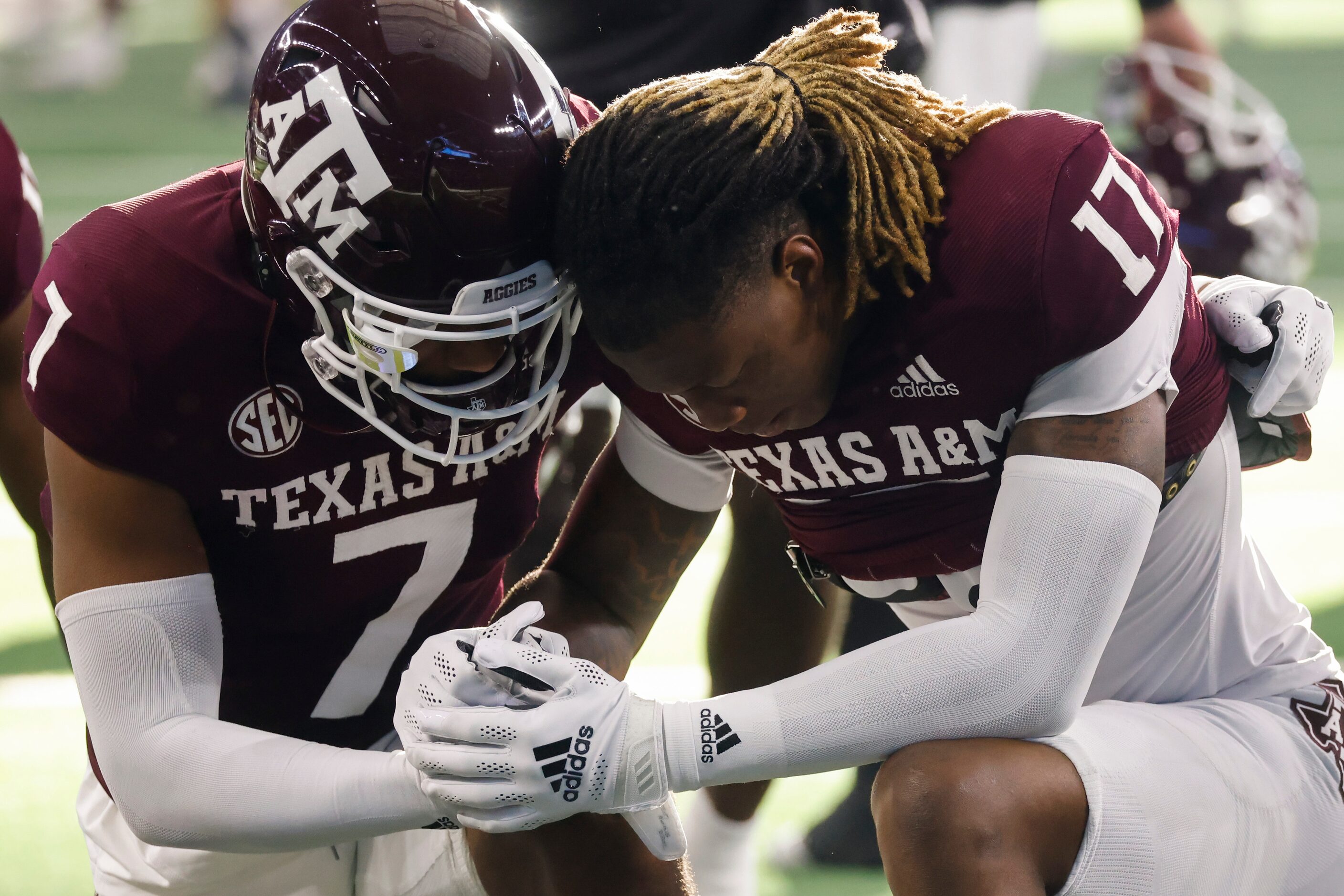 Texas A&M wide receiver Moose Muhammad III (7) and defensive back Jaylon Jones (17) pray...