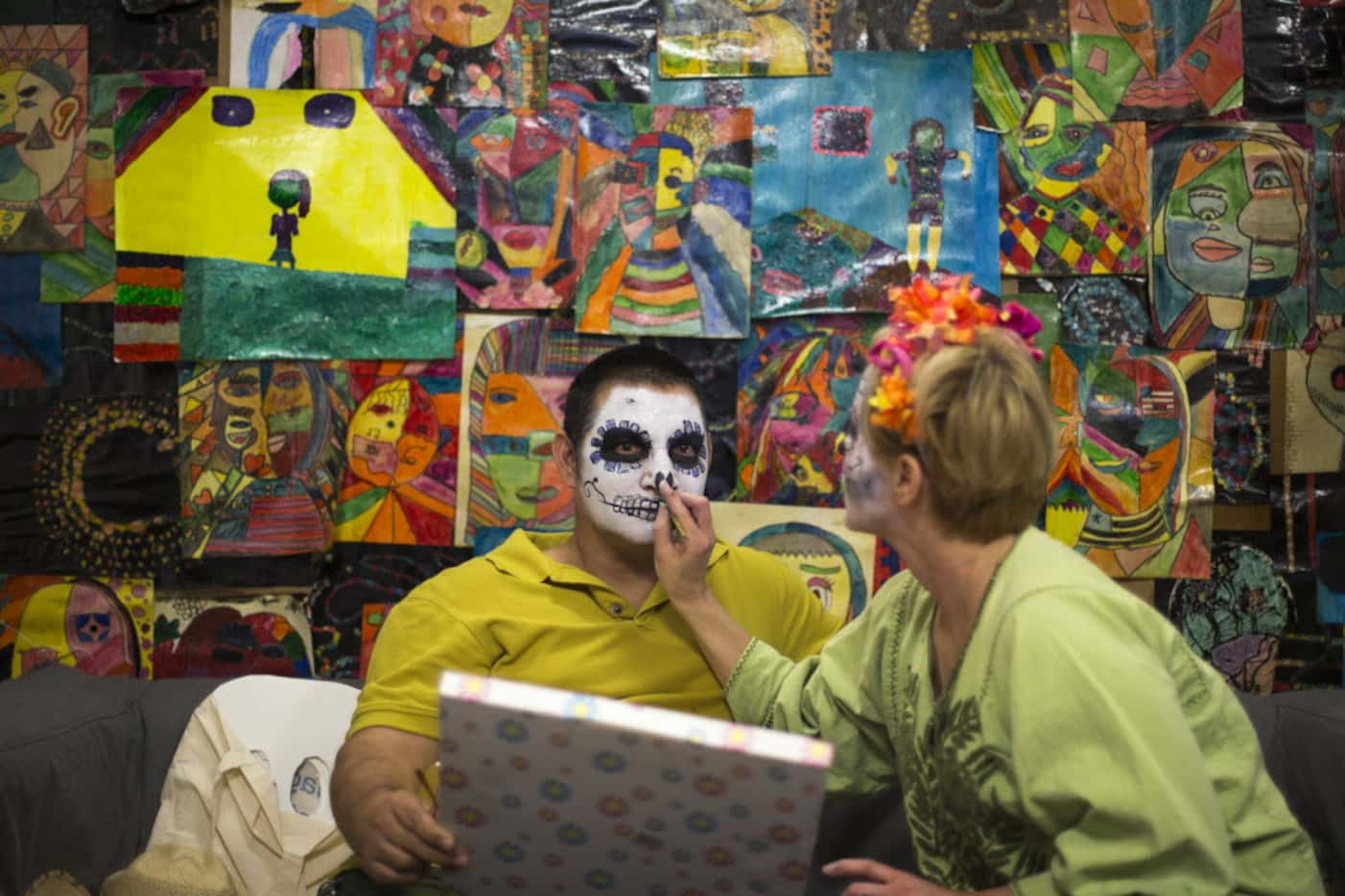 Alfredo Herrera, left, has his face painted during a Dia de los Muertos celebration in 2015...