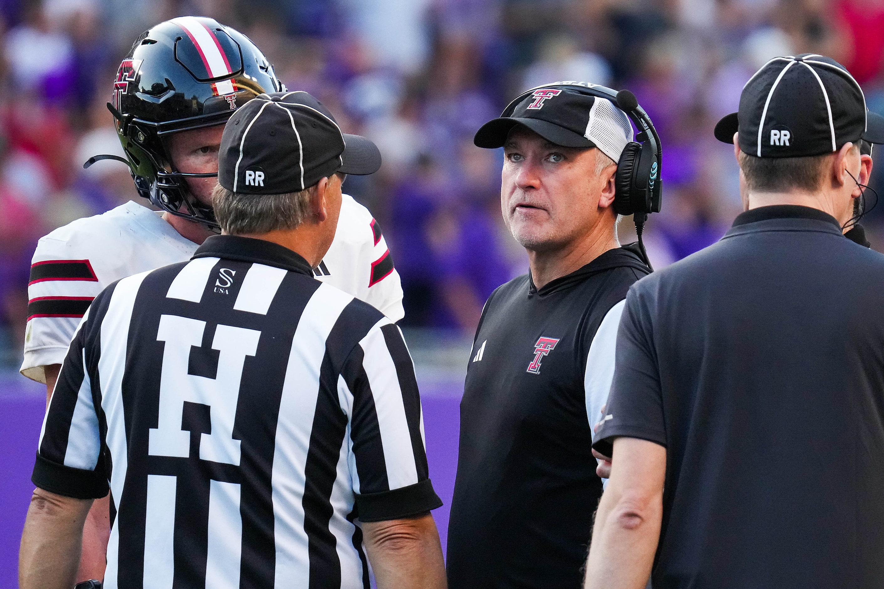 Texas Tech head coach Joey McGuire and quarterback Will Hammond talk with officials after a...