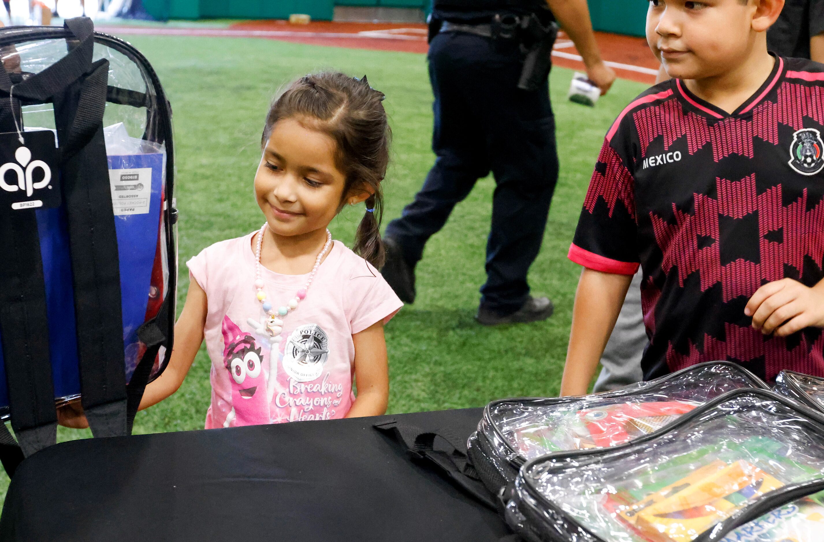 Renata Sarinana (left), 5, smiles after selecting a free backpack stuffed with school...