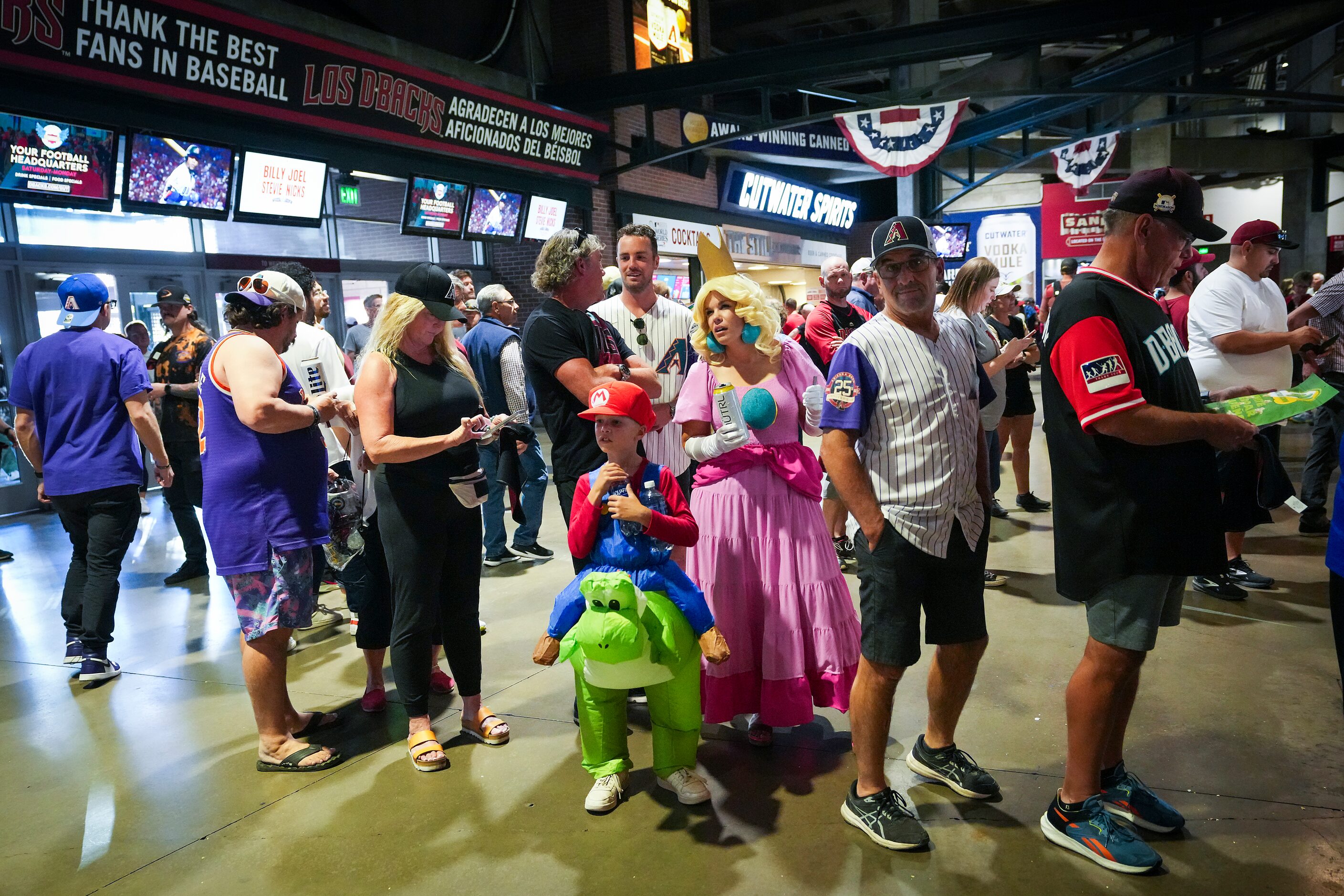 Fans are seen dressed in costumes for Halloween as they wait in a concession line before...