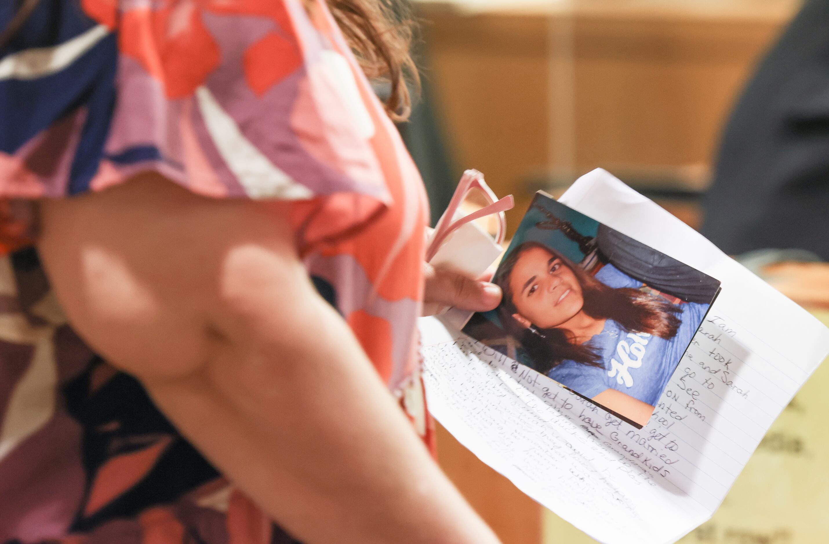 Patricia Owens holds photos of her daughter 17-year-old Sarah Said as she walks up to the...