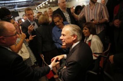  Texas Gov. Greg Abbott (center) shakes hands with State Rep. Kenneth Sheets, R-Dallas, at...