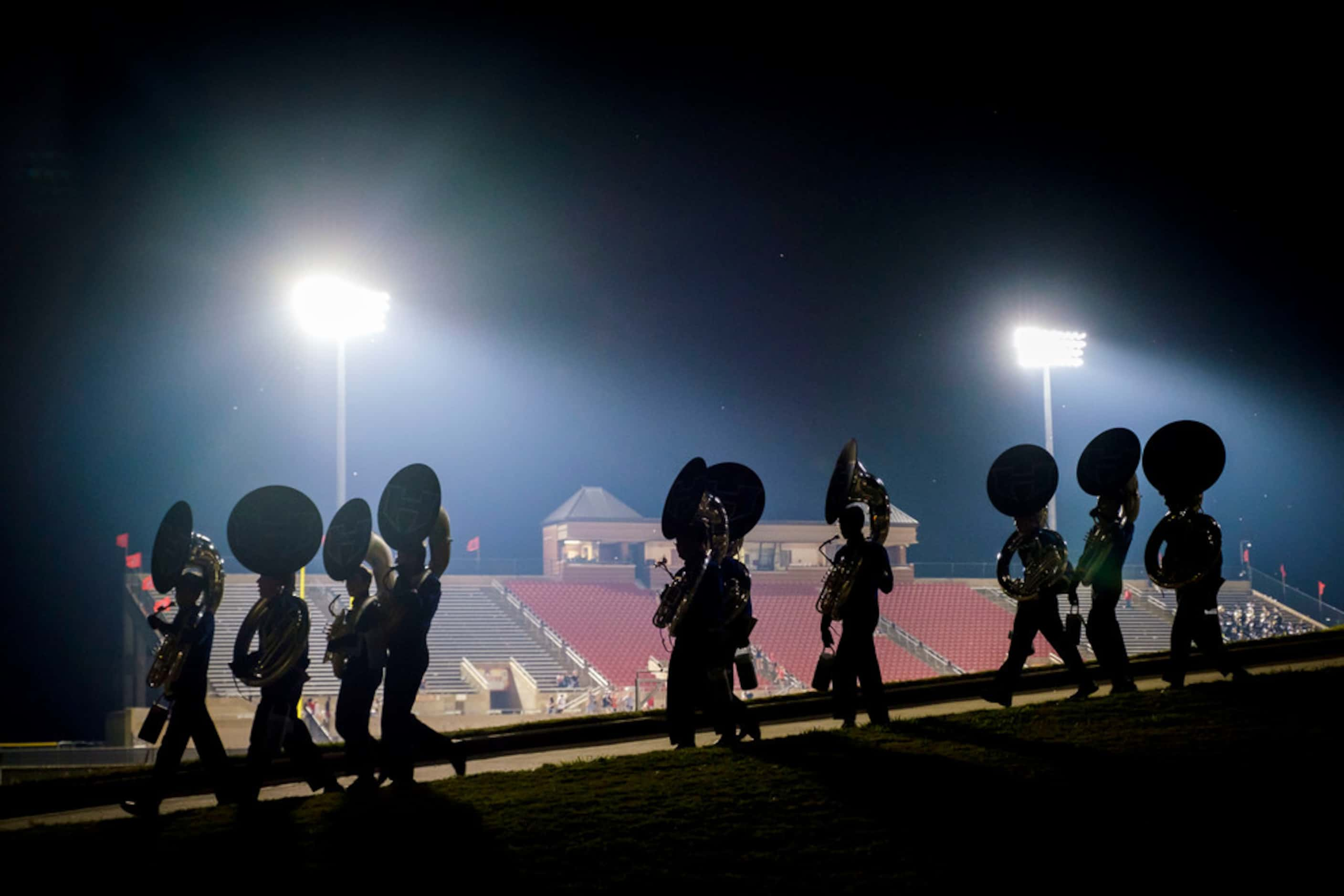 Members of the Hebron band head for the buses after a victory over Coppell in a high school...