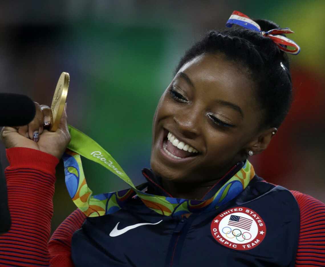 United States' Simone Biles displays her gold medal for floor during the artistic gymnastics...