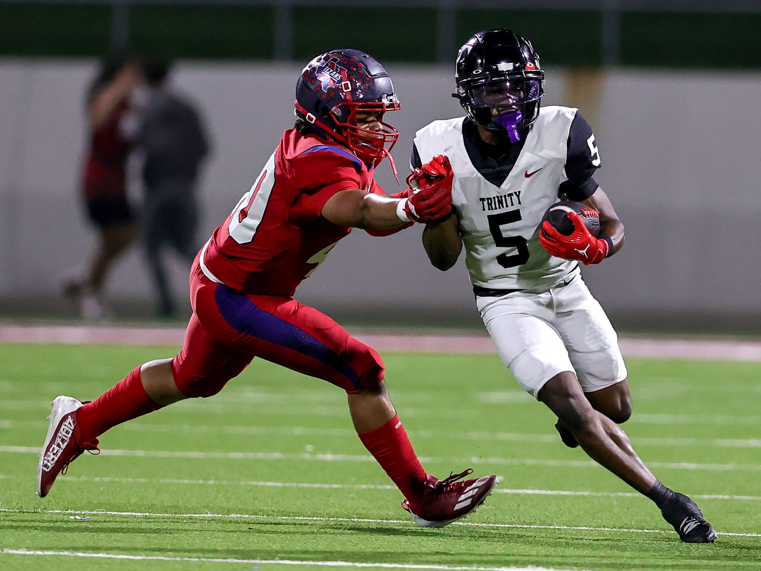 Trinity wide receiver Ethan Wright (5) tries to avoid Justin Northwest defensive lineman...