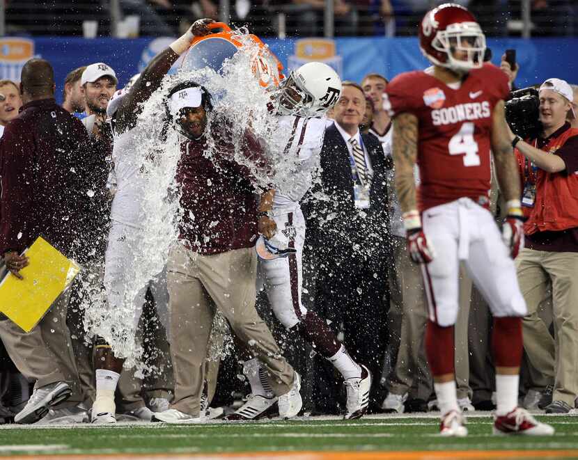 Texas A&M Aggies head coach Kevin Sumlin is hit with a water bucket at the end of the Aggies...