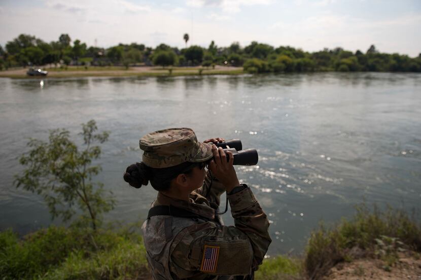 A Texas National Guard soldier watches over the Rio Grande in Starr County, Texas, April 10,...