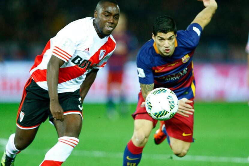 Eder Balanta of River Plate chases FC Barcelona's Luis Suarez in the final of the FIFA Club...