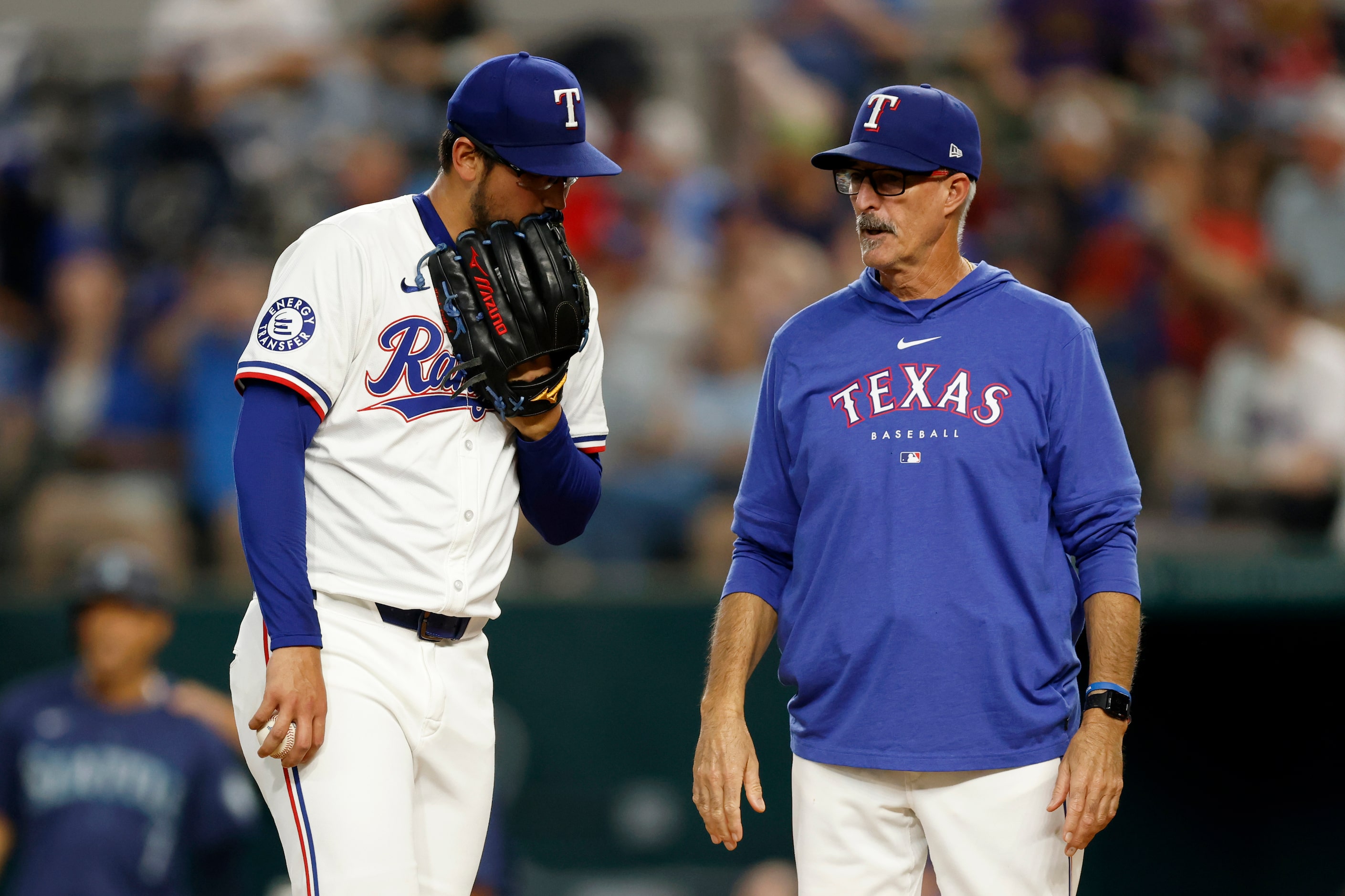 Texas Rangers pitching coach Mike Maddux talks with starting pitcher Dane Dunning (33) after...