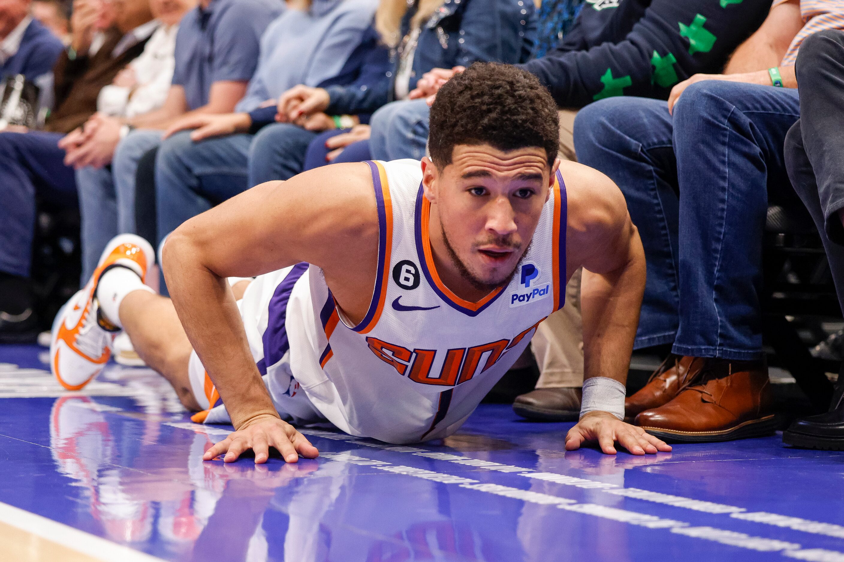 Phoenix Suns guard Devin Booker (1) helps himself off the court after colliding with Dallas...