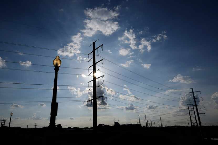 Large electrical transmissions lines are pictured along the Trinity River levee near...