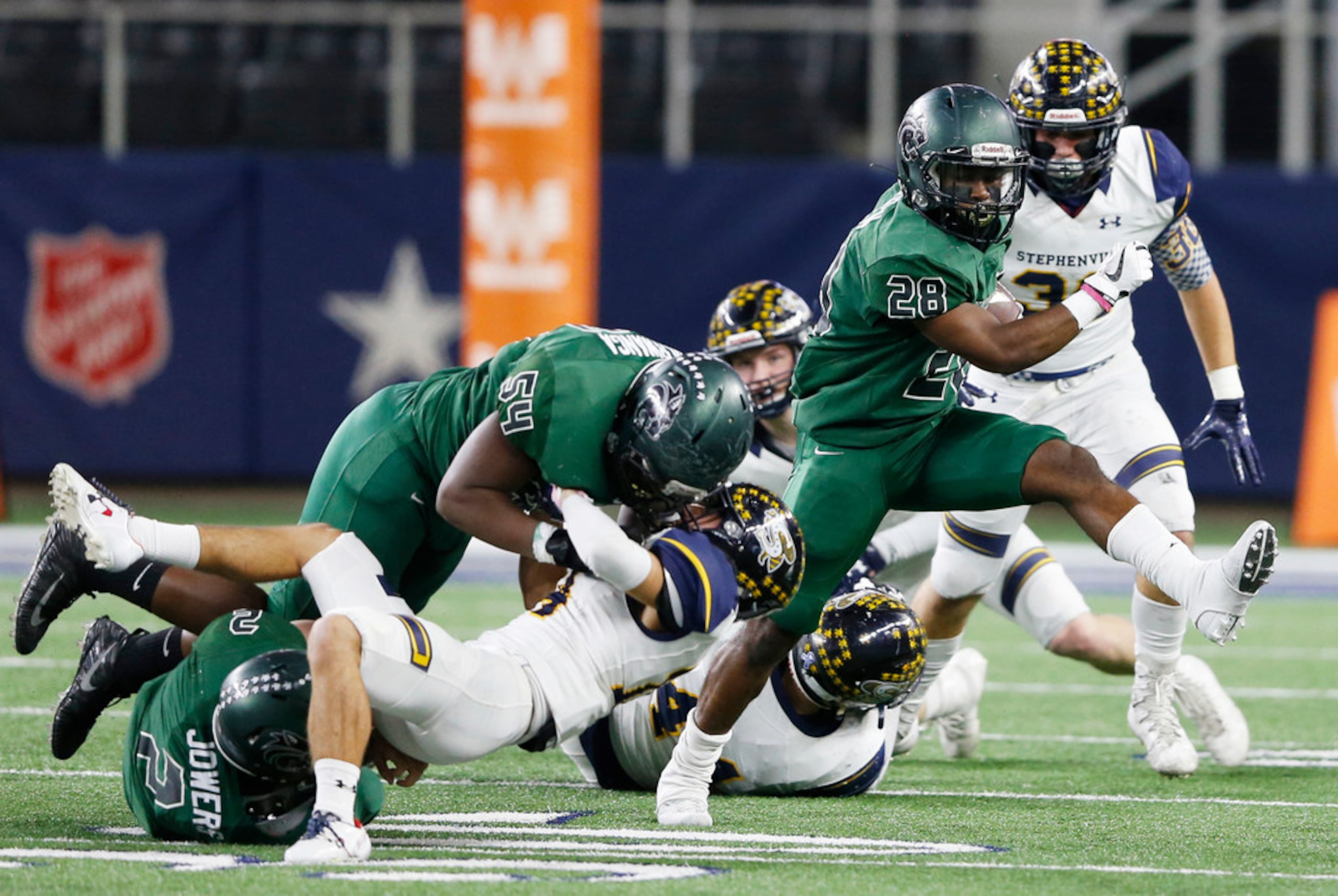 Kennedale's DJ Kirven (28) gets a block from teammates Chris Serwanga (54) and Evan Jowers...