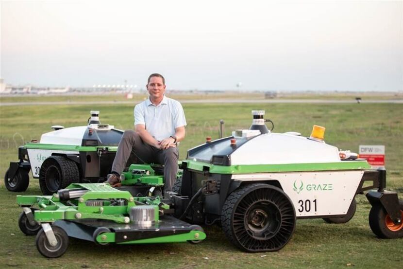 Graze Inc. CEO Logan Fahey with his company's autonomous commercial lawn mowing equipment.
