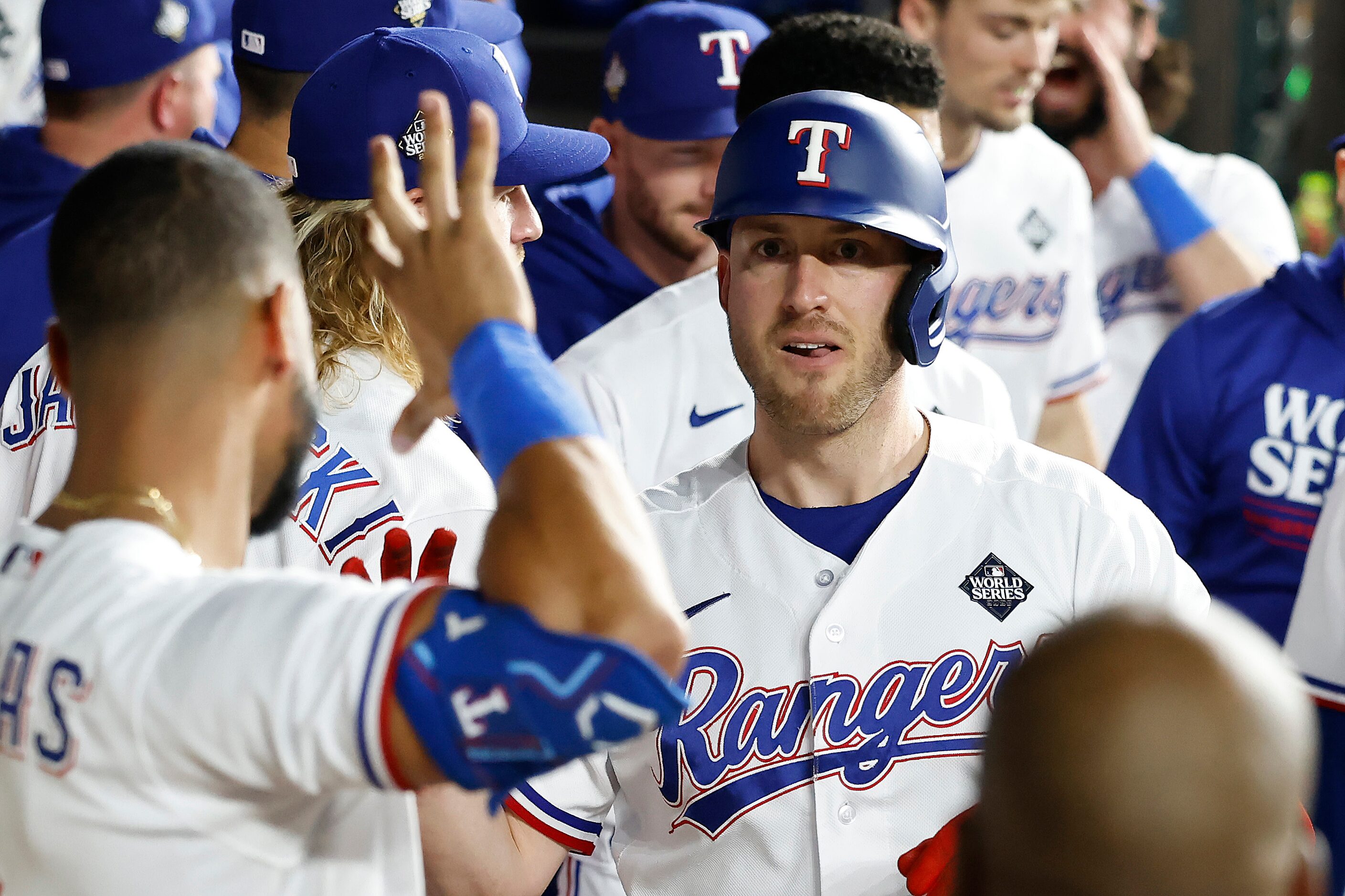 Texas Rangers designated hitter Mitch Garver is congratulated in the dugout after hiting a...