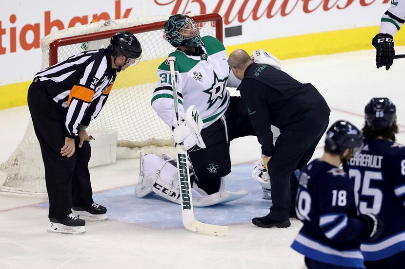 Dallas Stars goaltender Ben Bishop (30) is attended to by team staff for an apparent injury...