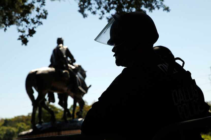 A Dallas police officer kept guard over removal of the Robert E. Lee statue from Robert E....