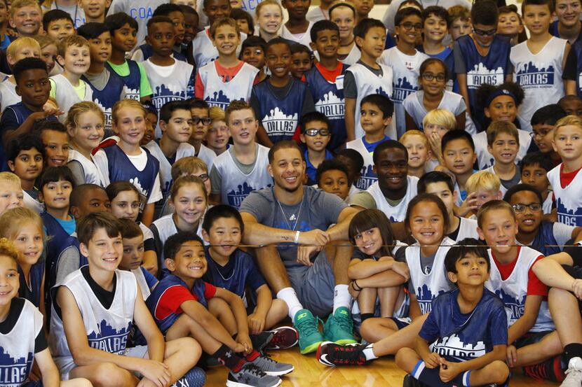 Mavericks guard Seth Curry has his photo taken with Mavs Basketball Academy Hoop Camp at...