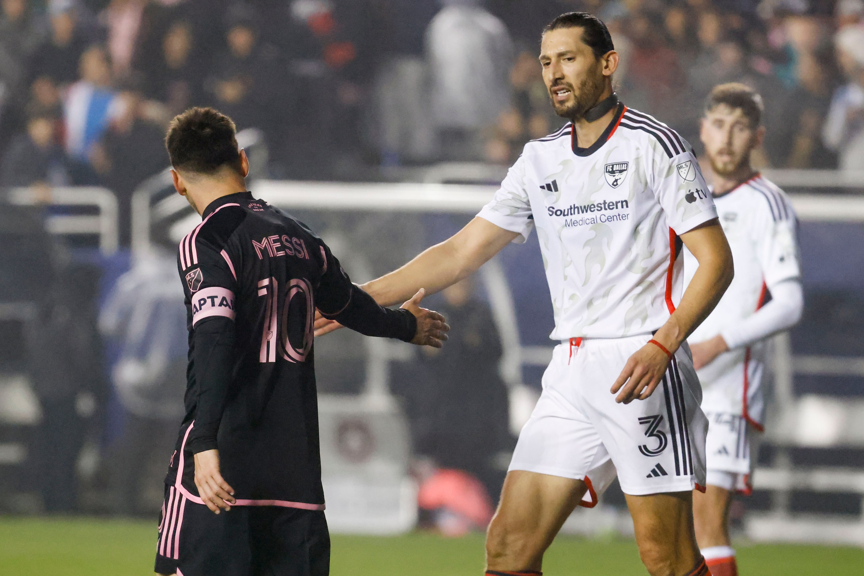 Inter Miami forward Lionel Messi (left) gives a five to FC Dallas defender Omar Gonzalez...