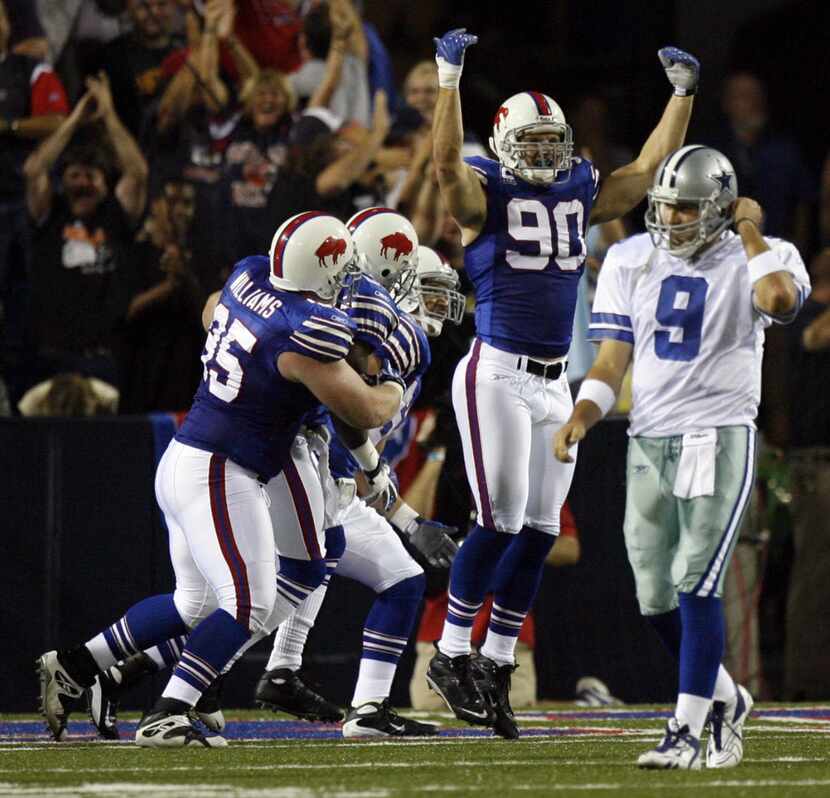 Dallas Cowboys  quarterback (#8) Tony Romo walks away as  Buffalo Bills defender (#90) Chris...