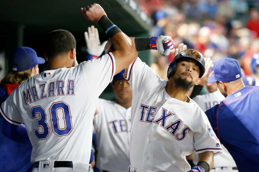 Texas Rangers second baseman Rougned Odor (12) is congratulated by right fielder Nomar...