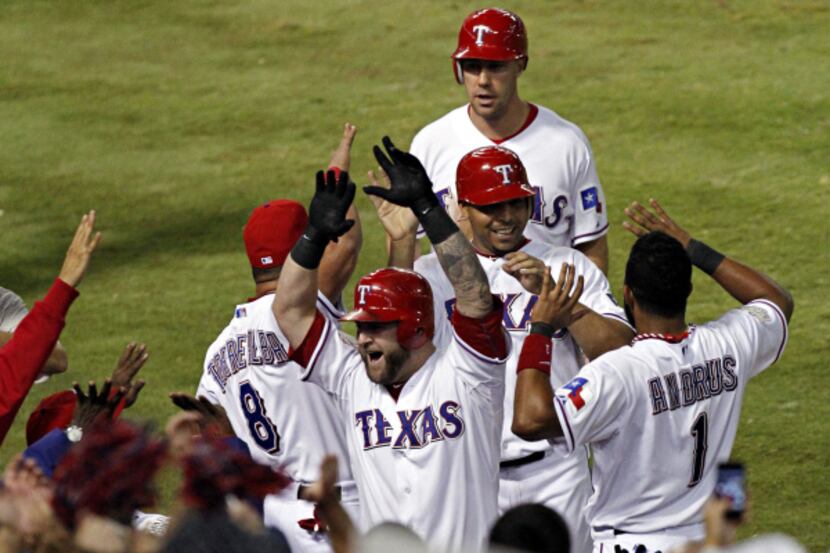 Texas Rangers catcher Mike Napoli celebrates with teammates after his sixth inning three-run...
