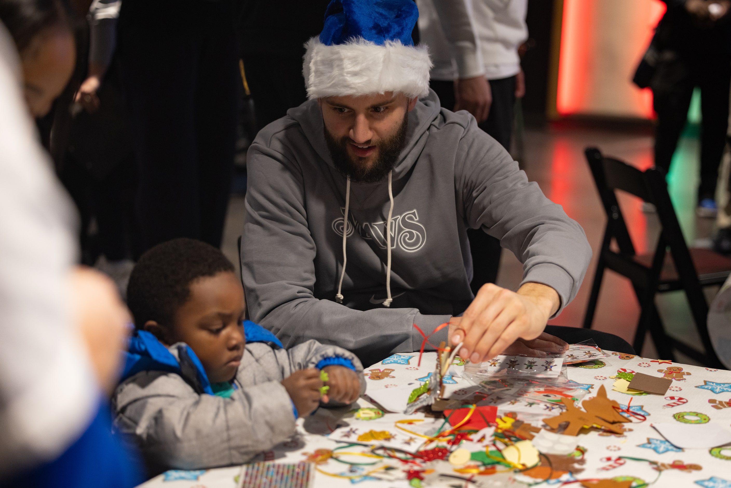  Mavericks forward Maxi Kleber helps kids make crafts during the Cookies With Santa event in...