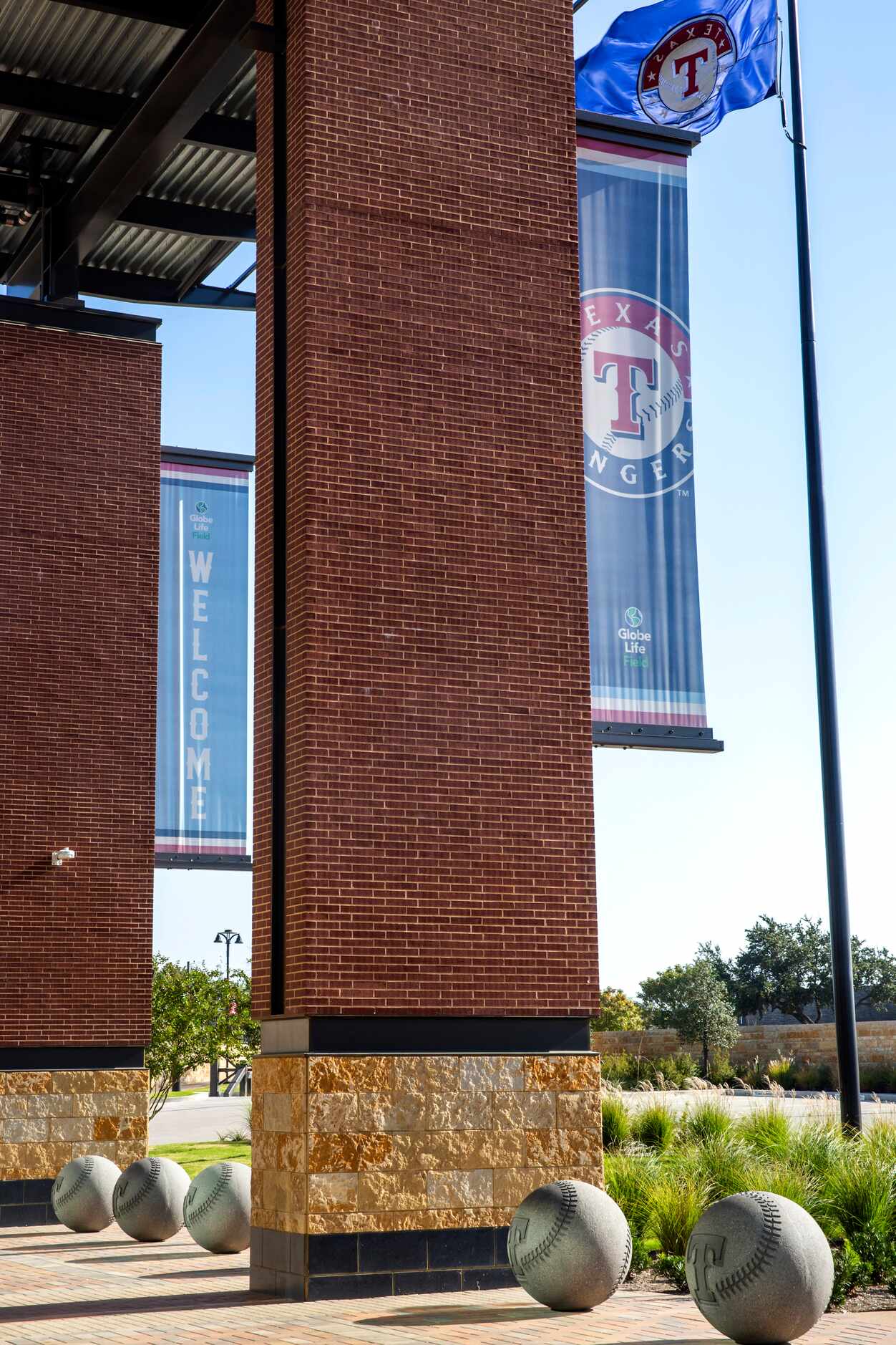 Piers supporting parts of Globe Life Field feature Texas stone, a connecting course of black...