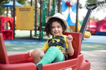 Child plays on red playground equipment