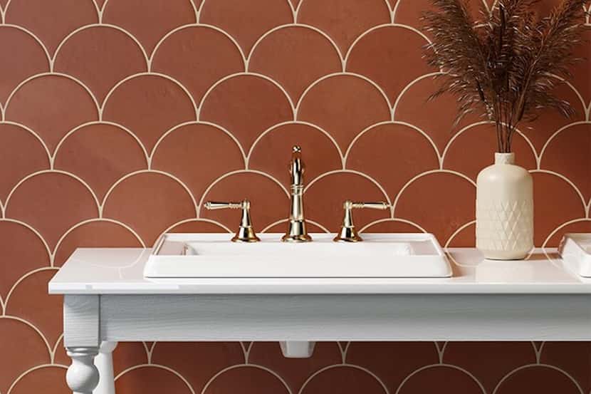 Terra-cotta tiles on a backsplash stand out in contrast to a white bathroom vanity table and...