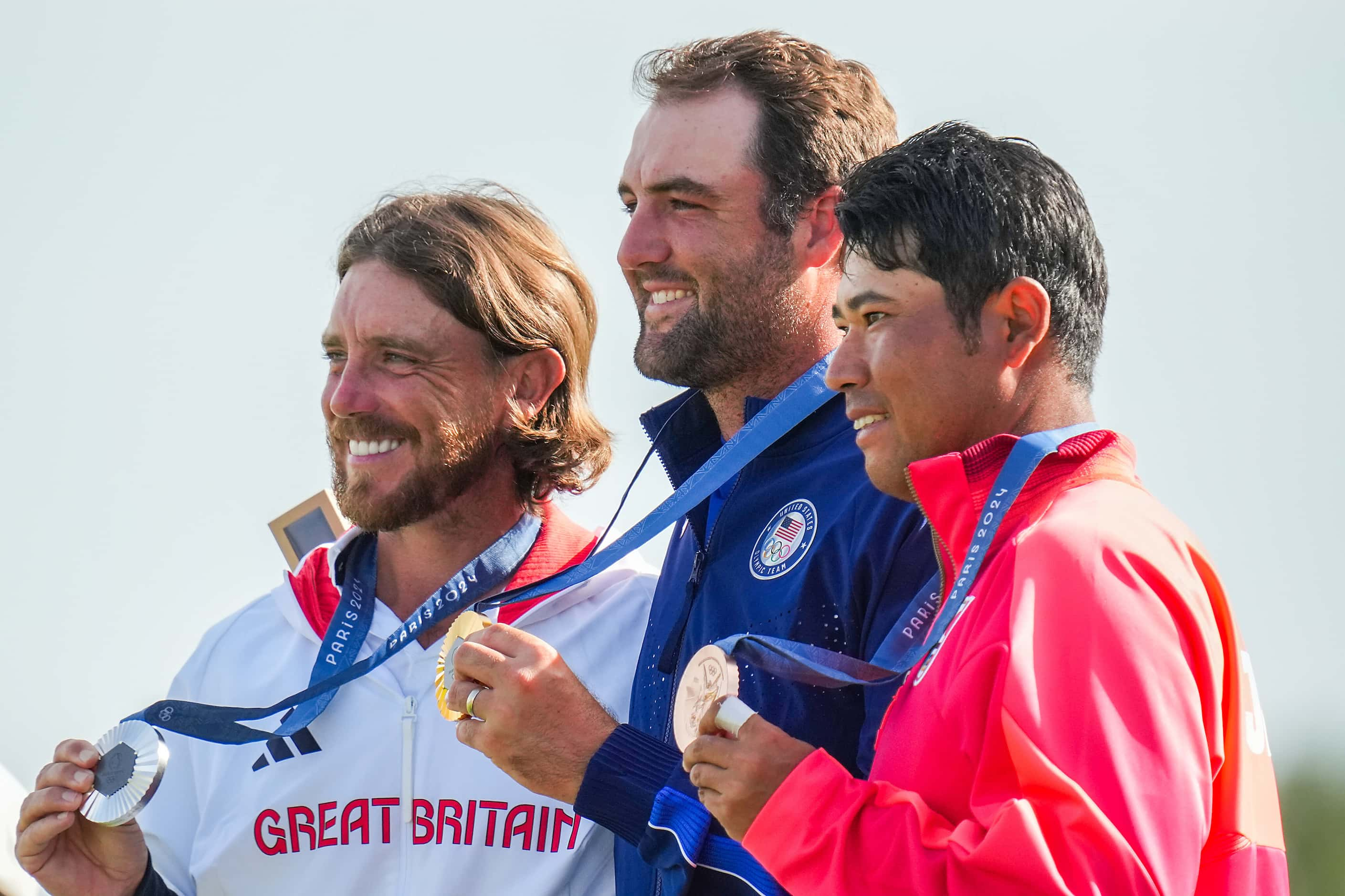 Gold medalist Scottie Scheffler of the United States (center) poses with silver medalist...