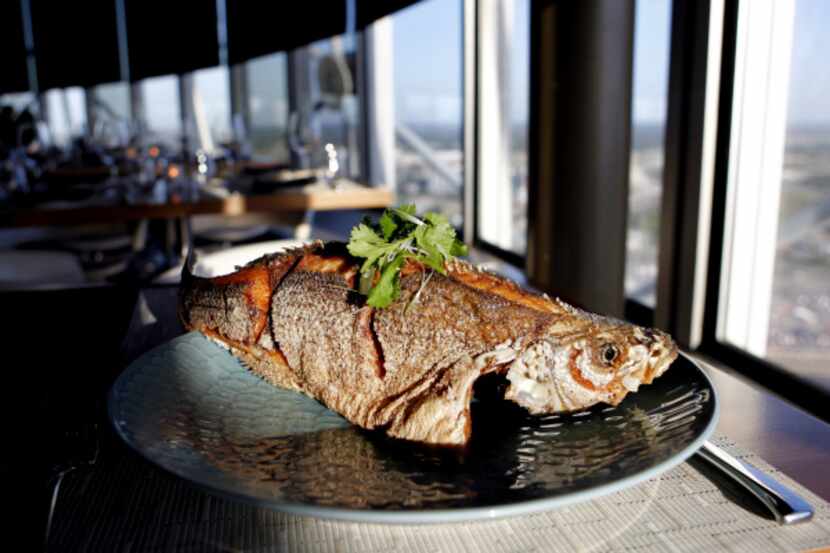 Wok-fried whole sea bass is stuffed with cilantro and ginger and served with a...