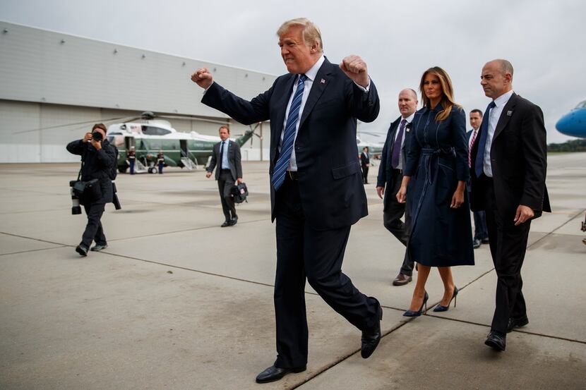 President Donald Trump pumps his fist as he greets supporters after landing at...