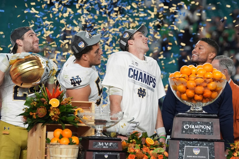 Notre Dame head coach Marcus Freeman and members of the team celebrate after winning the...