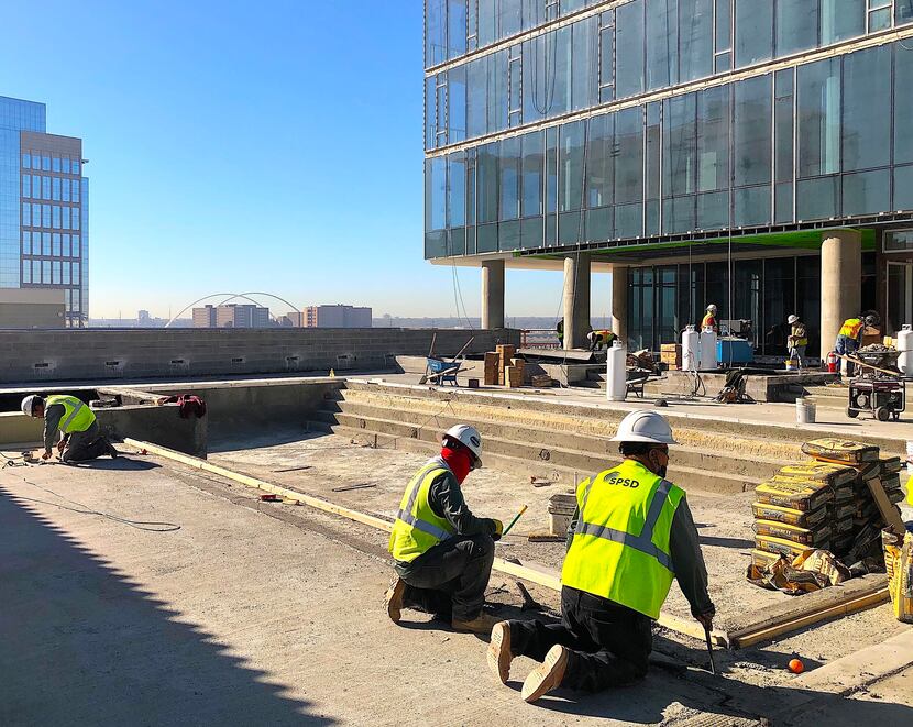 Construction crews work on the pool deck at The Victor apartment tower in Victory Park.