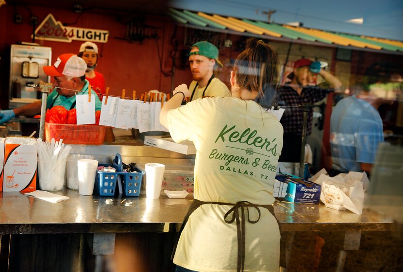 As seen through the window, carhop Sadie Townsel clips new food orders to the wire for chefs...