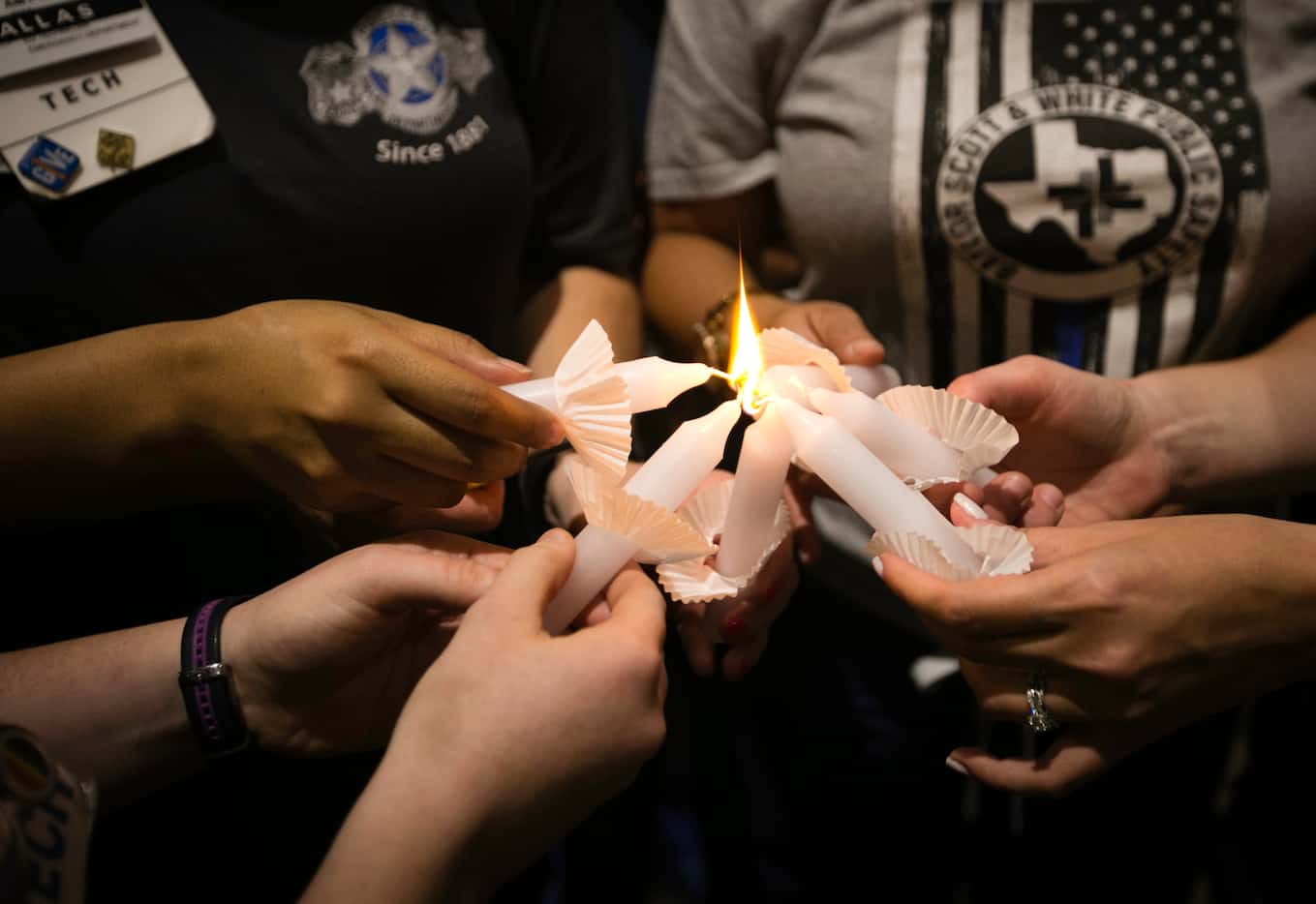 Baylor University Medical Center employees light candles during a vigil held outside the...