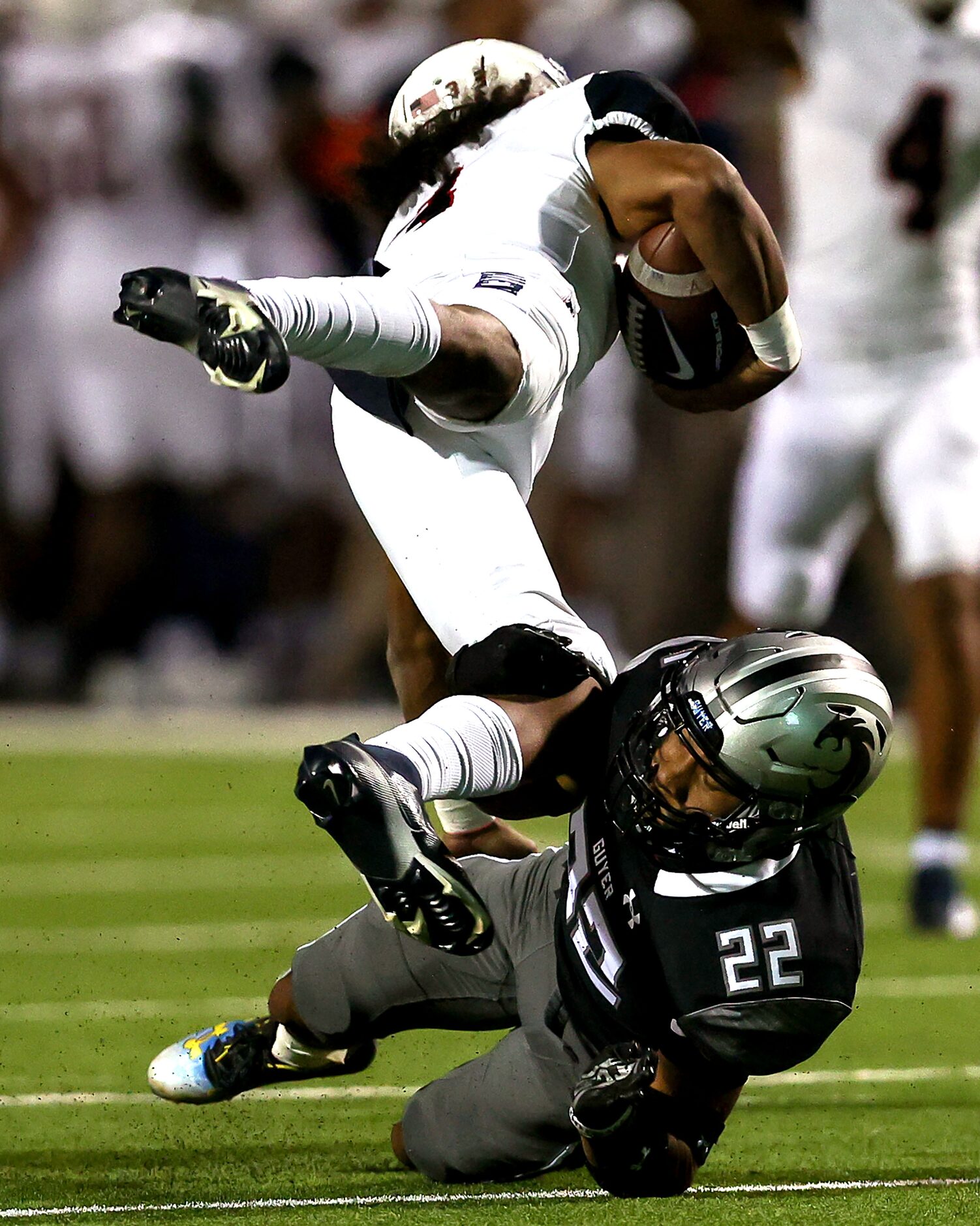 Denton Guyer defensive back Peyton Bowen (22) trips up Allen quarterback Mike Hawkins (3)...