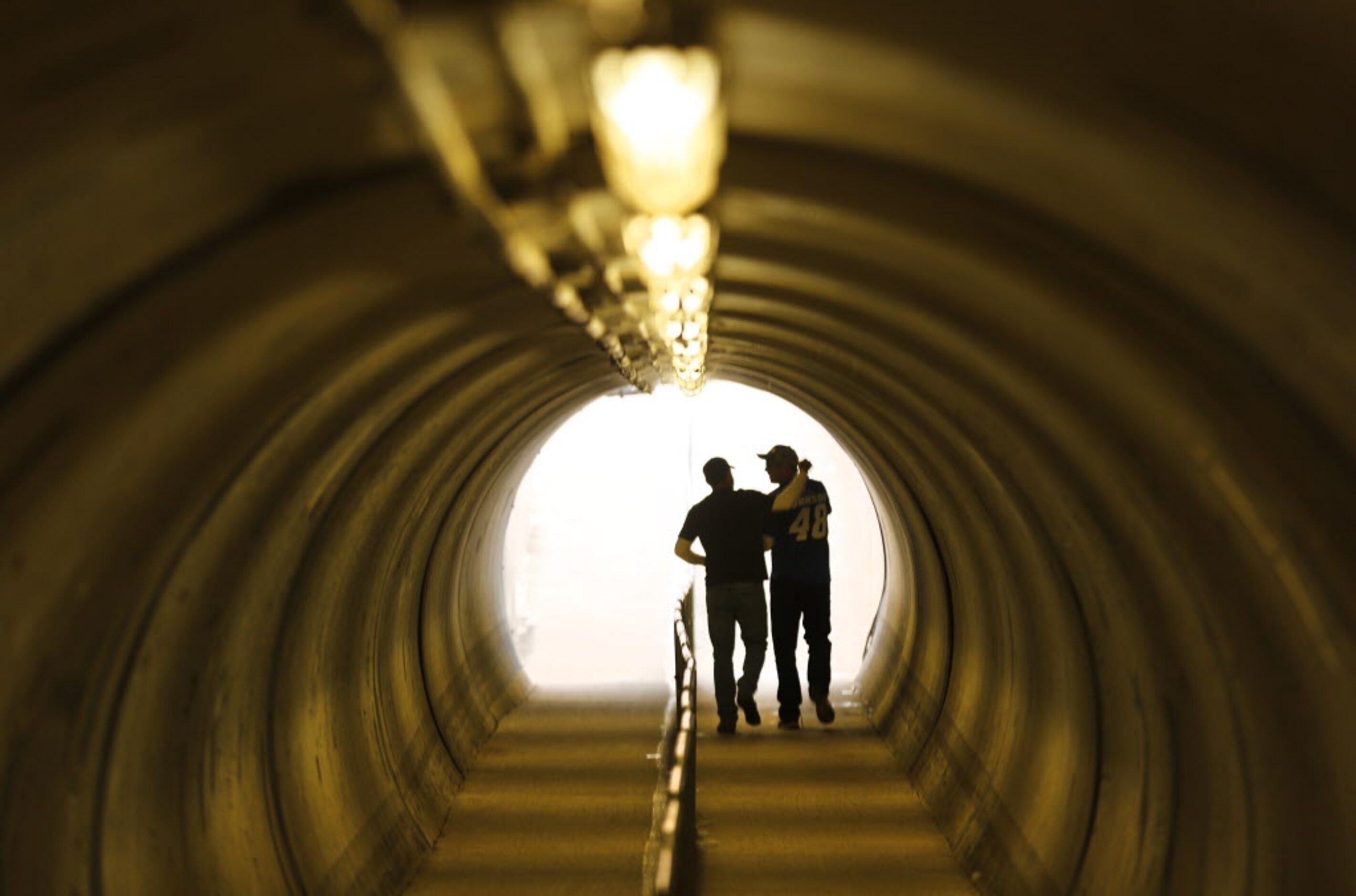 A pair of good buddies walk through the Barr Tunnel that runs under the track during the AAA...