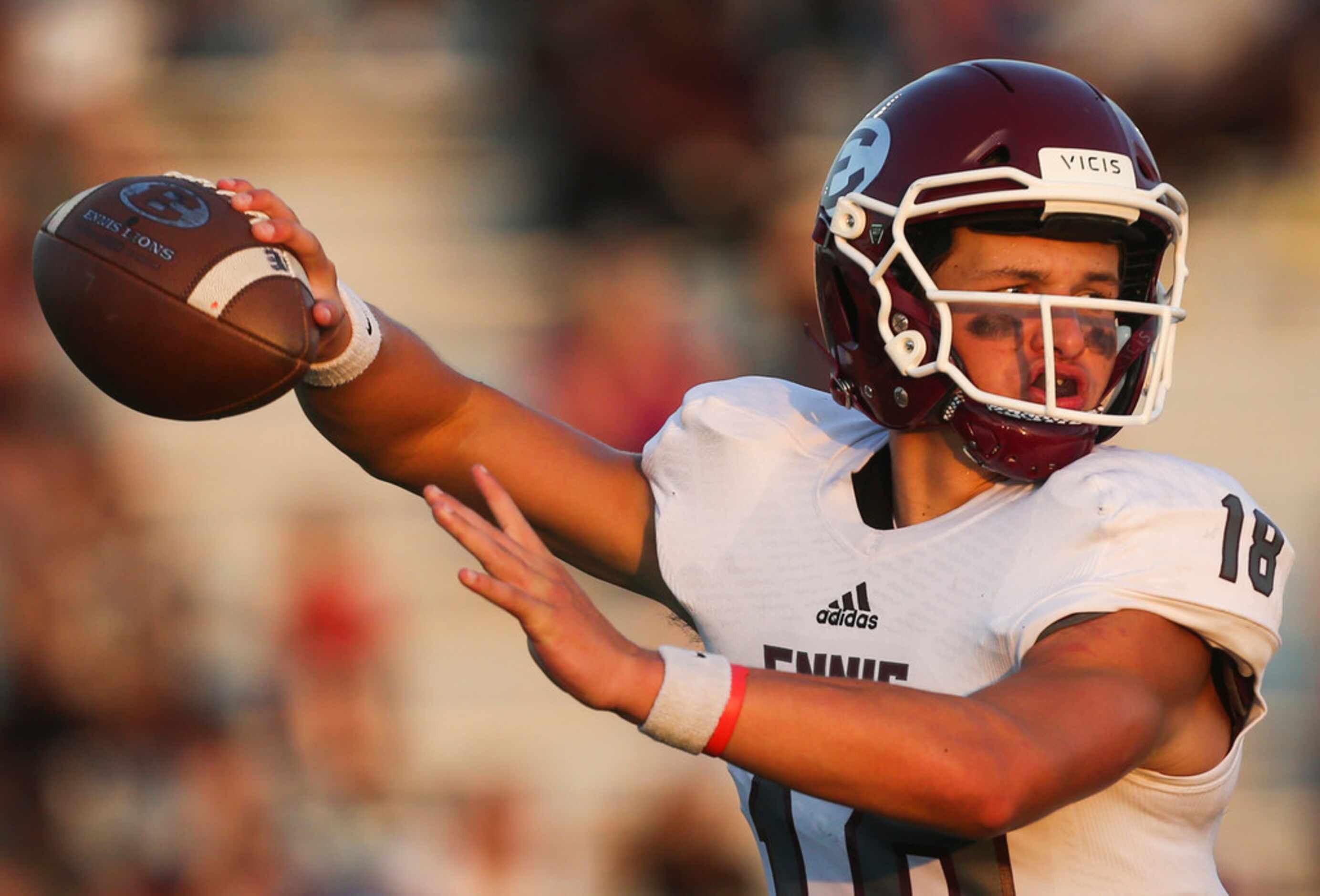 Ennis quarterback Collin Drake (18) fires off a pass during a high school football game...
