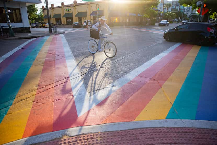 A cyclist bikes past the new rainbow crosswalks on Cedar Springs and Throckmorton St. in Oak...