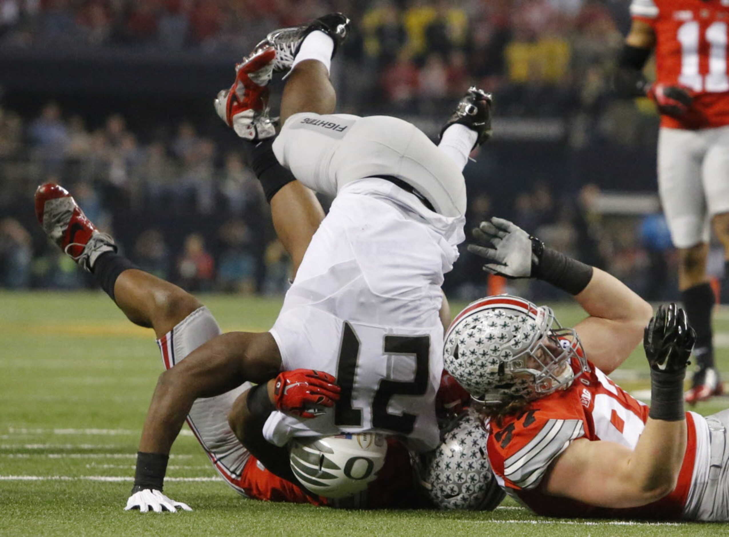 Ohio State Buckeyes defenders including defensive lineman Joey Bosa (97) tackle Oregon Ducks...