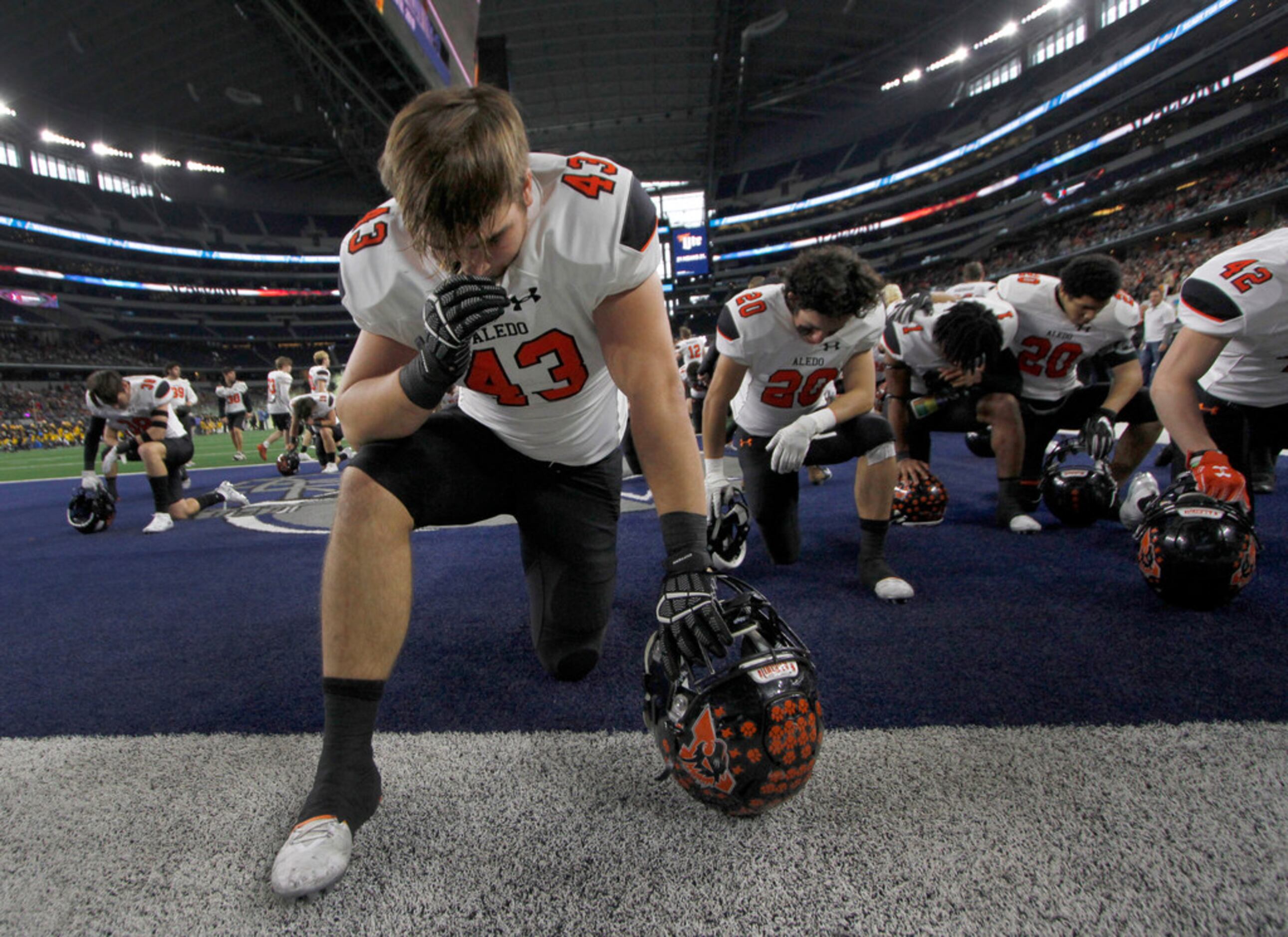 Aledo defensive lineman Kyle Thompson (43) pauses to pray with teammates before the opening...