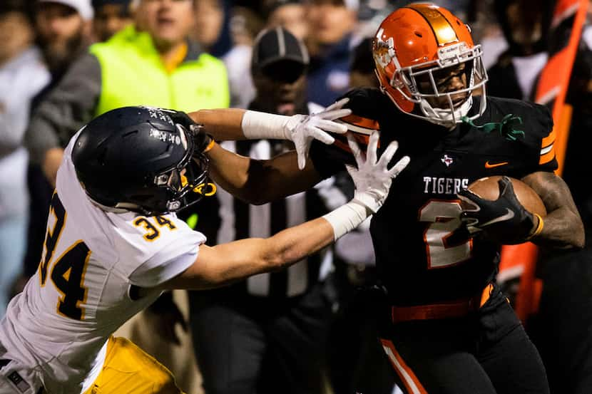 Highland Park's Sam Sessions (34) pushes Lancaster running back Tre Bradford (2) out of...