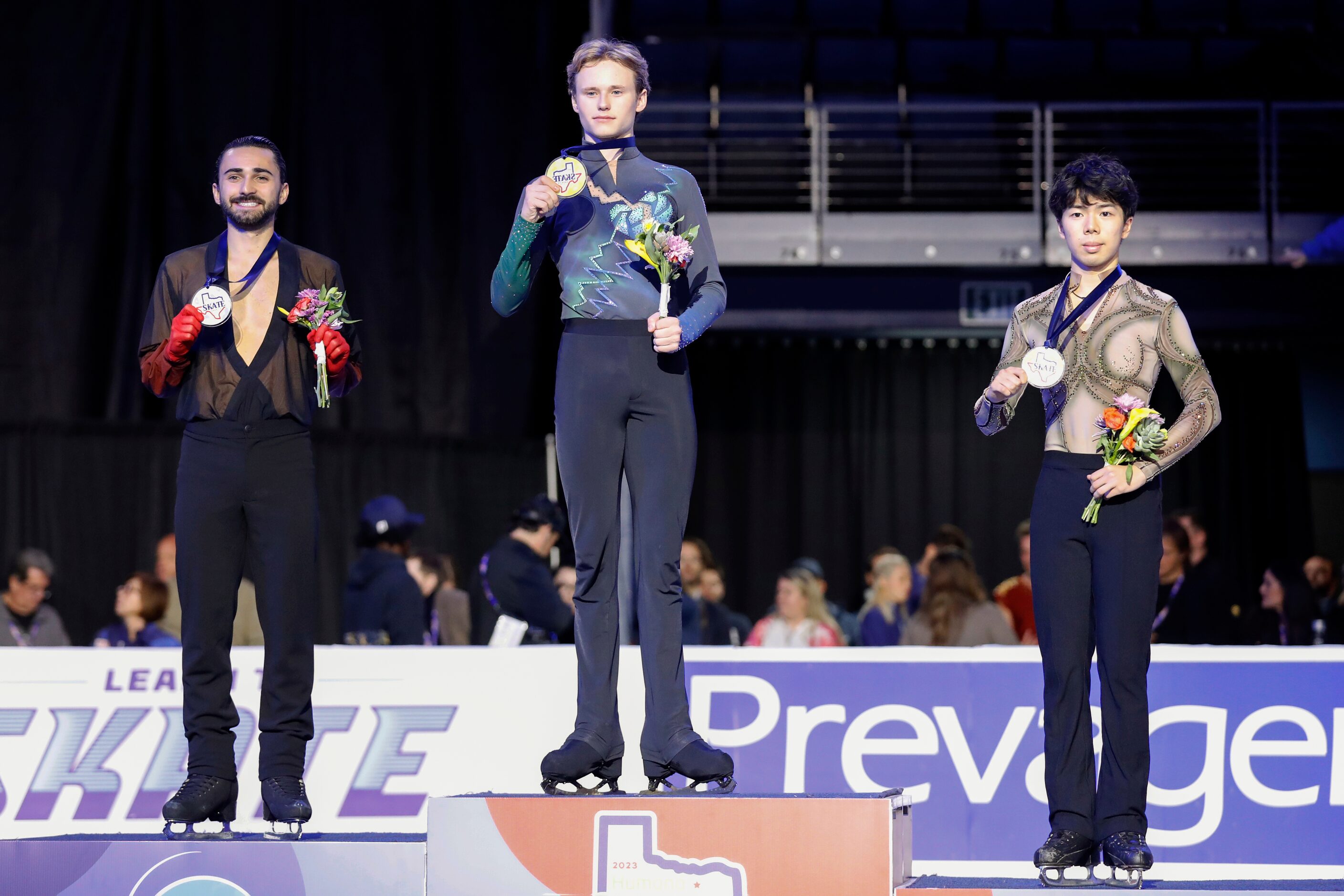 Ilia Malinin, of the United States, center, stands on the podium after winning the gold...