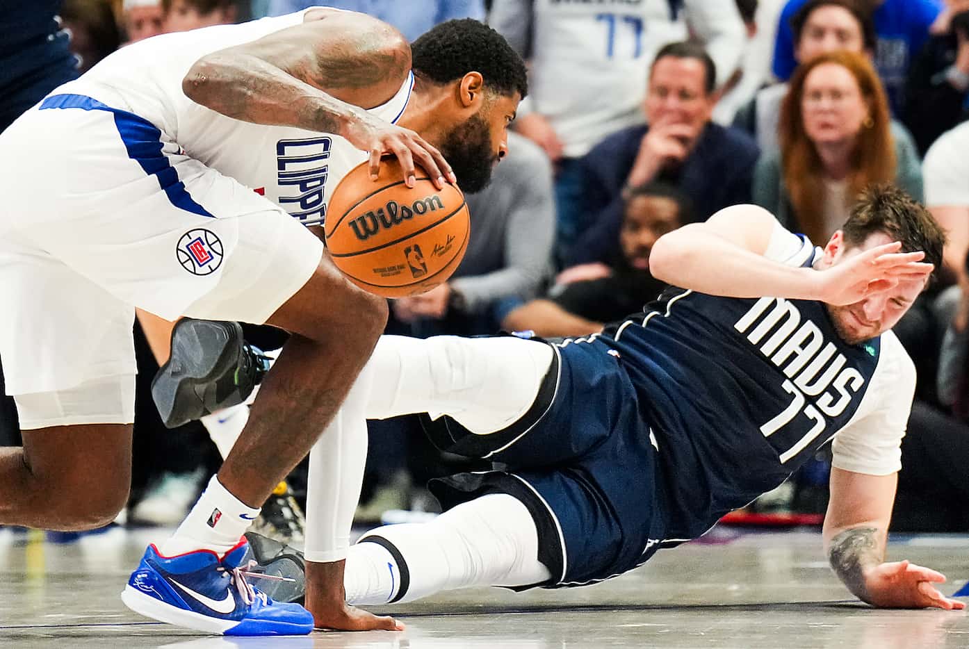 Dallas Mavericks guard Luka Doncic (77) falls to the floor as he collides with LA Clippers...