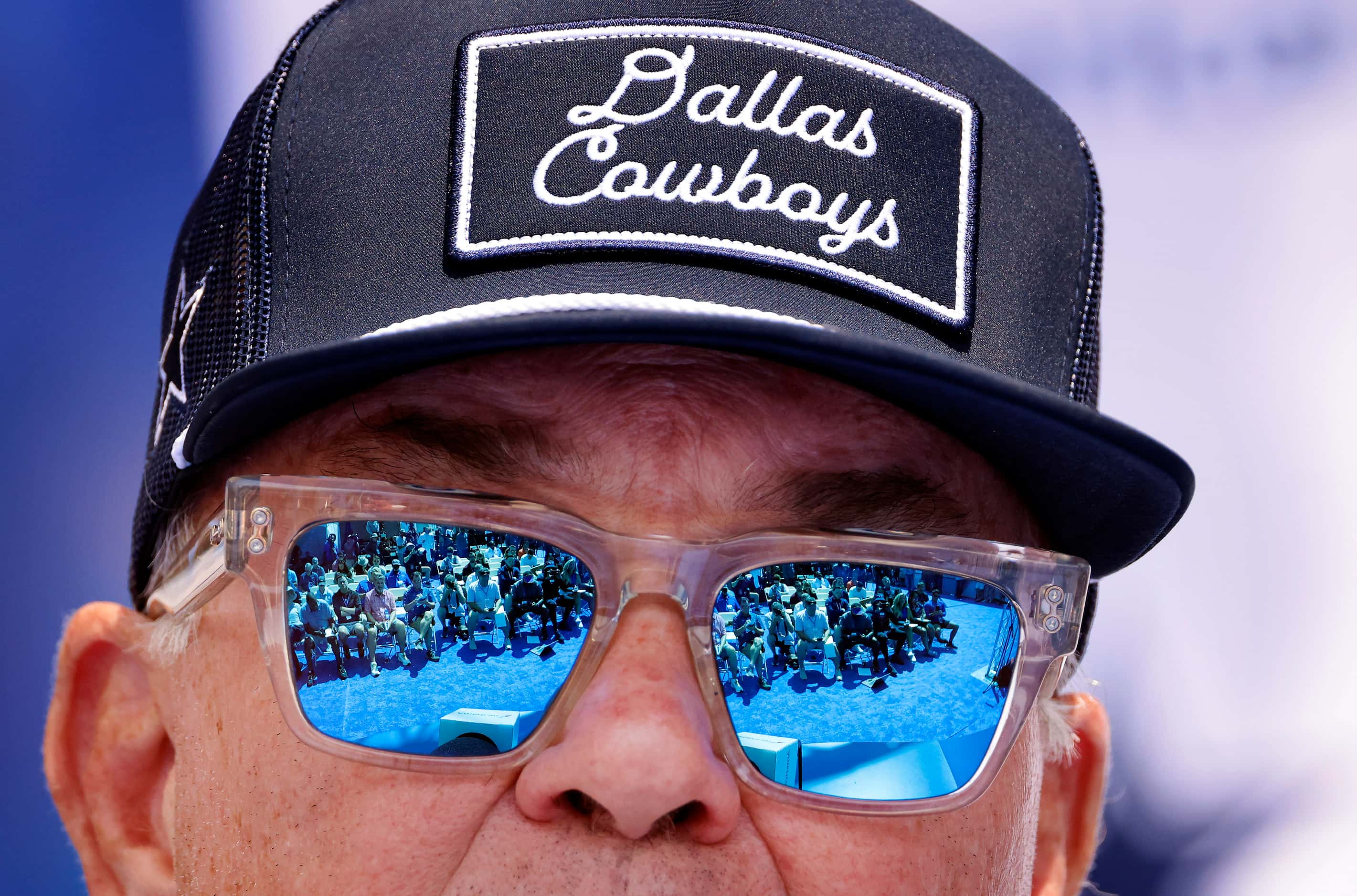 Members of the media are reflected in the sunglasses of Dallas Cowboys executive vice...
