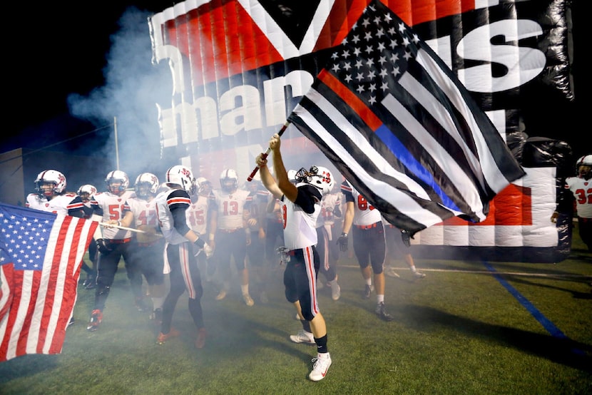 Flower Mound Marcus football players honor first responders with a special flag as they...