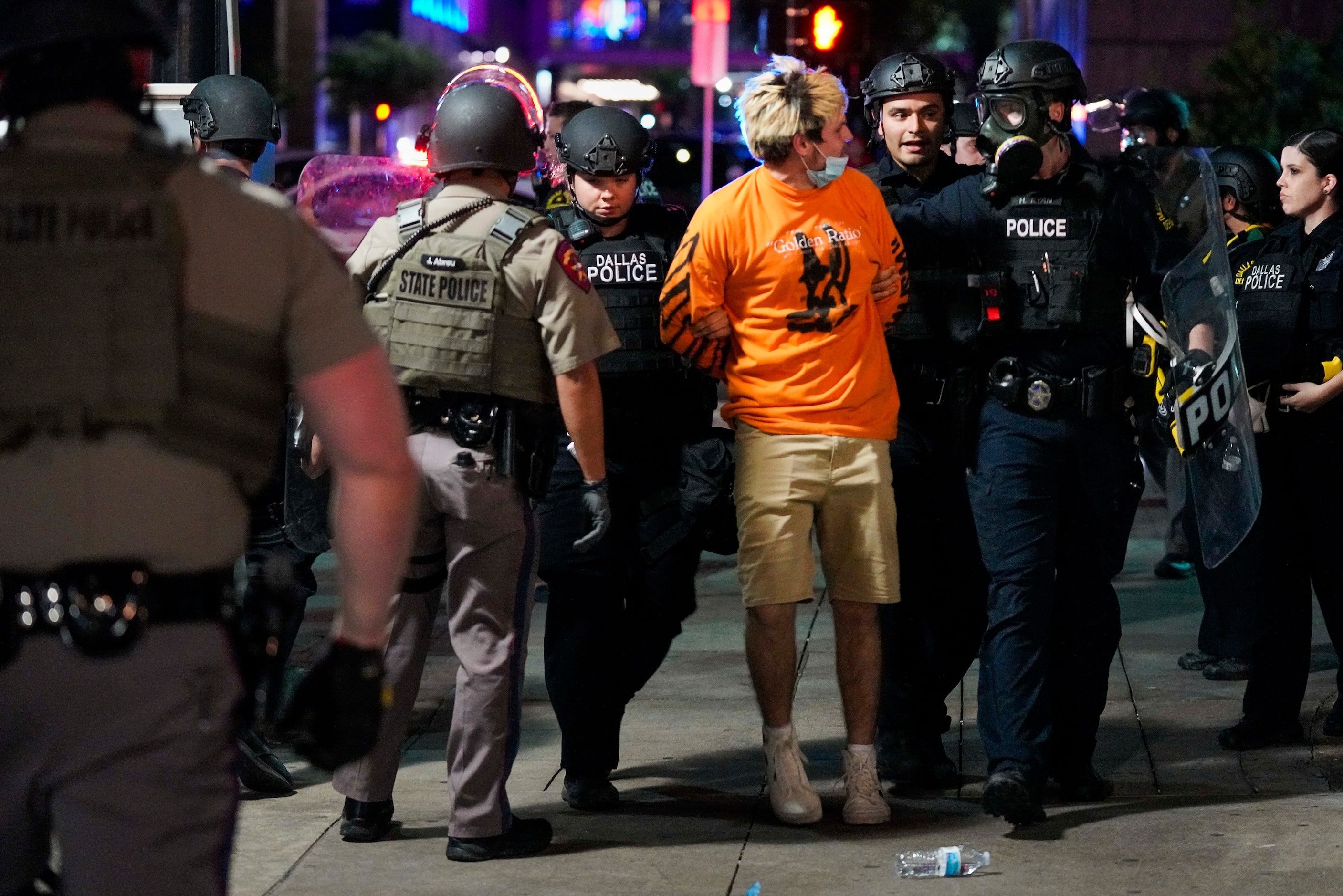 Dallas police arrest a man on Elm Street while working to clear groups of people from...